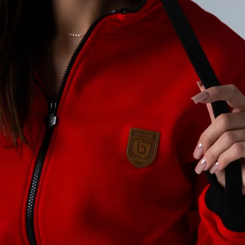 Czerwona bluza damska rozpinana z kapturem Czerwona bluza damska z czarnym suwakiem.webp